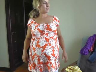 Enticing pregnant lady trying on dresses